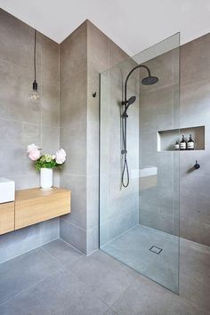 a bathroom with a sink, mirror and shower in it's center wall is shown