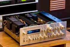 an electronic device sitting on top of a wooden table in front of a sound board