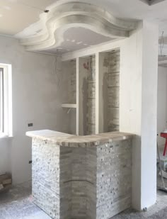 an unfinished room with a stone bar in the middle