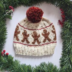 a white and brown knitted hat sitting on top of a christmas wreath