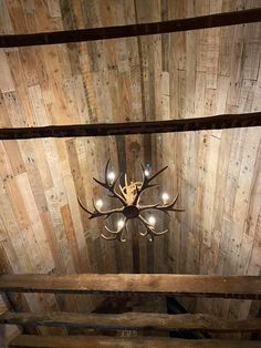 a chandelier hanging from the ceiling in a wooden room