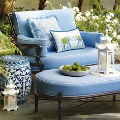 an outdoor patio with blue furniture and white flowers