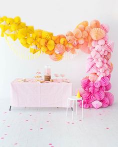 a table topped with lots of pink and yellow decorations