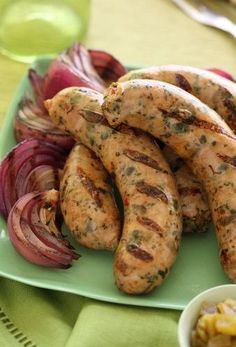 grilled sausages and onions on a green plate