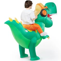 a young boy riding on the back of an inflatable dinosaur