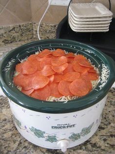 a crock pot filled with cooked carrots on top of a granite countertop