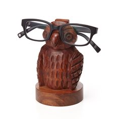 an owl with glasses on top of it's head sitting on a wooden stand