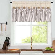 a kitchen window with striped curtains and utensils on the windowsill, next to a cutting board