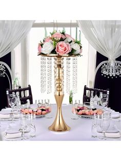 a fancy table setting with pink roses and crystal chandelier in the centerpiece