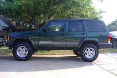 a green jeep parked in front of a house