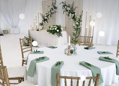 a white table topped with green napkins and flowers