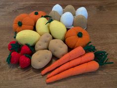 a pile of carrots and other vegetables on a wooden table with eggs in the background