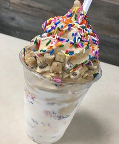 an ice cream sundae with sprinkles and toppings in a plastic cup