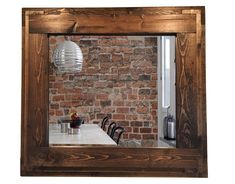 a table with chairs and a brick wall in the background is reflected in a mirror