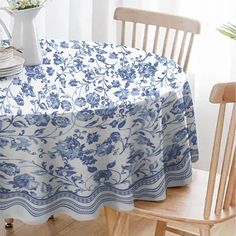 a blue and white tablecloth on a wooden chair in front of a vase with flowers