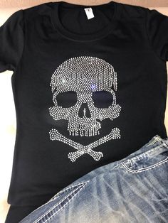 "This is a very cool skull shirt that shines from every angle.   You can wear this shirt while on the town, shopping, or at concerts. This shirt contains rhinestones, so please wash with care. This design measures 7\"WX10\"H. I use a heat press machine and use very high -quality rhinestones. Please note that every shirt is a handmade product so the exact placement of the rhinestone design might not be the exact same as you see in the listing photos.  Also, the color on computer monitors varies, so color of the actual product may be different than what you see in the photos. Please message me if you are interested in V-neck shirts.  However, this is a big design so the V-neck shirt pushes the design lower. **PLEASE VIEW SIZE CHART on the photo portion of this listing.  Women's Relaxed Jerse Rhinestone Tshirt Designs, Heavy Metal Tshirt, Metal Tshirt, Rhinestone Tshirts, Tang Top, Bling Shirt, Rhinestone Shirt, Rhinestone Projects, Cap Decoration