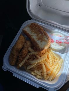 a sandwich and fries in a plastic container