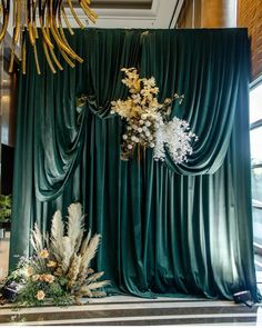 a green curtain with white flowers and greenery