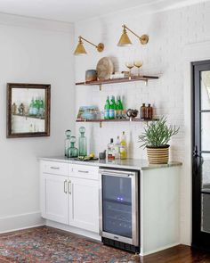 a kitchen with white cabinets and open shelving on the wall next to a potted plant