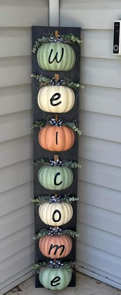 pumpkins are arranged in the shape of numbers on a wall hanging from a door