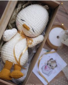 a crocheted white stuffed animal in a box