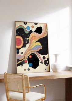 a painting on a wall next to a desk with a chair in front of it