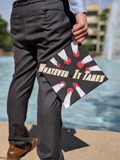 a man in business attire holding a bag that says whatever it takes on his feet