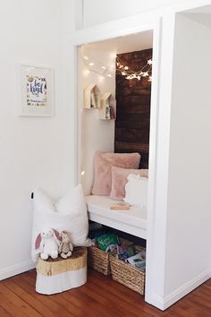 a white room with a bench and some pillows