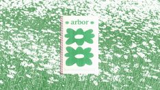 a notebook with the word arbor written on it in front of a field of flowers