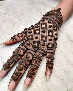 the hand is decorated with intricate designs and hearts on it's palm, which has been