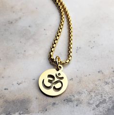 "《《  SYMBOLIC COLLECTION  》》 THE DETAILS The \"GOLD OM COIN\" Necklace is designed with an ultra shiny Gold Stainless Steel Coin Pendant, intricately engraved with a Cut Out Om Symbol!! Hung from a Gold Stainless Steel Box Chain available in your choice of length!! THE SYMBOL 🕉OM: Known as the \"SOUND of the UNIVERSE\", as it is the sound that unifies all living beings and represents all points in time, all states of being, all levels and consciousness;  all that ever was, ever is, and ever wil Gold Chain Lockets For Men, Mens Gold Pendant Designs Unique, Men Pendant Design, Om Locket Gold For Men, Om Pandent Design For Men, Om Gold Rings, Om Pendant For Men, Om Pendent