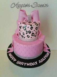 a pink and black birthday cake decorated with leopard print, bow, and diamond accents