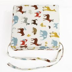 a white bag with colorful animals on it's side and a lanyard around the strap