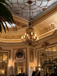 people are sitting at tables in an ornately decorated dining room with chandelier