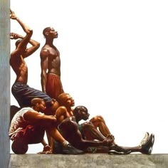 a group of men standing and sitting on top of a cement wall next to each other