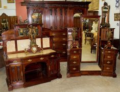 antique furniture is displayed in a store with mirrors and other items on the floor,