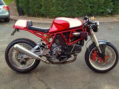 a red and white motorcycle parked on the street