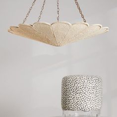 a white cake sitting on top of a table next to a hanging light fixture above it