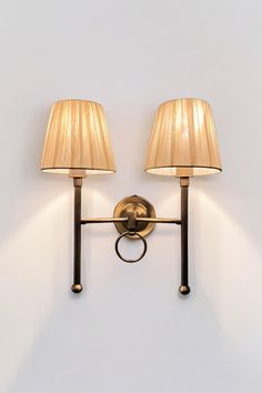 two lamps mounted on the wall next to each other with one light on it's side