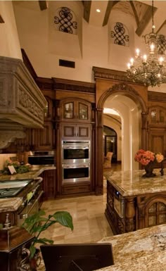 a large kitchen with an island and chandelier hanging from it's ceiling