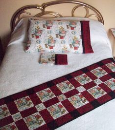 a bed topped with two pillows and a quilted runner on top of the bed