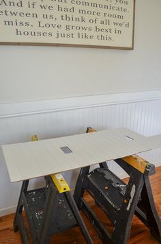 two work benches sitting next to each other on top of a hard wood floor in front of a white wall