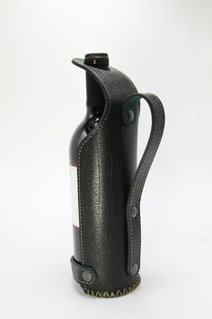 a black leather wine bottle holder with a green stitching around the top and bottom