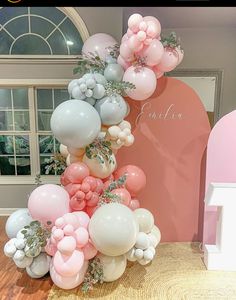 the balloon arch is decorated with pink, white and grey balloons