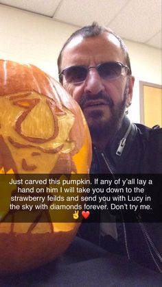 a man is holding a carved pumpkin with the letter k on it and an inscription that reads just carved this pumpkin, any if y'all