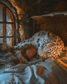 a woman laying in bed next to a snow leopard