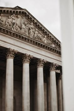 an old building with columns and statues on it