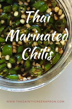 there is a glass bowl filled with green peppers and corn on the side that says thai marinated chilis