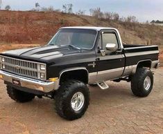 a black and silver truck parked on top of a dirt field