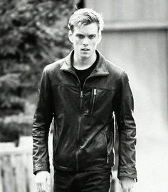 black and white photograph of a man walking down the street